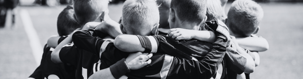 A group of young football players huddle together
