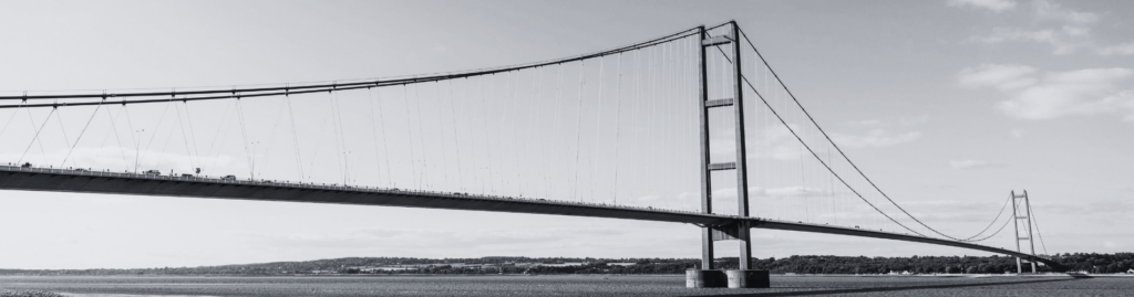 A long road bridge spans over an estuary